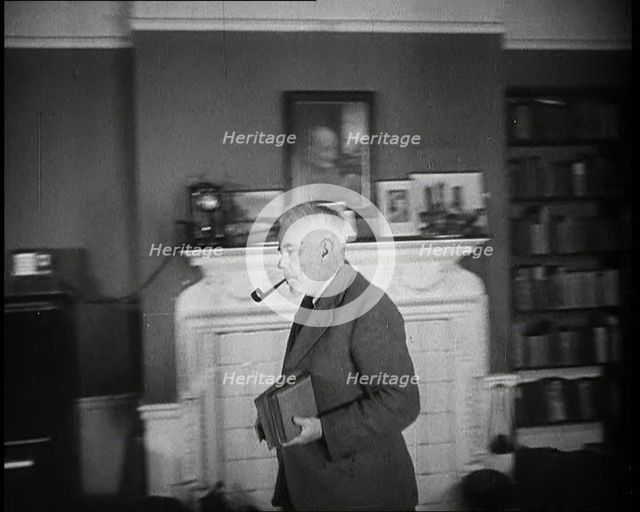 C.E.M Joad Taking Some Books to His Desk, 1930s. Creator: British Pathe Ltd.