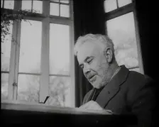 C.E.M Joad Sitting Down at His Desk, 1930s. Creator: British Pathe Ltd