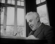 C.E.M Joad Sitting Down at His Desk, 1930s. Creator: British Pathe Ltd
