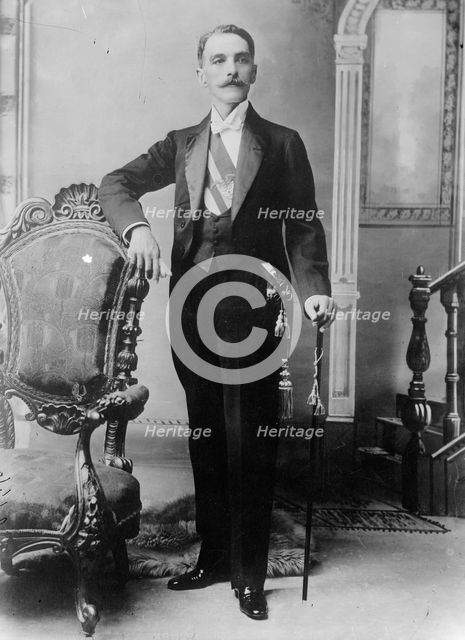 C.E. Restrepo posing next to chair, with cane, 1910. Creator: Bain News Service.