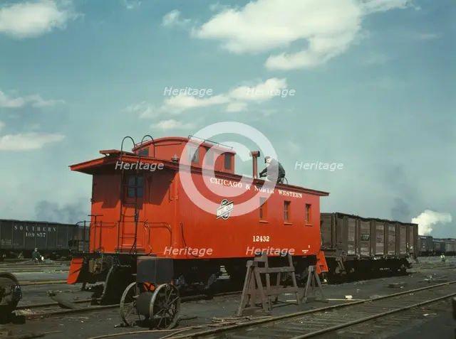 C & NW RR putting the finishing touches on a rebuilt caboose..., Proviso yard, Chicago, Ill., 1943. Creator: Jack Delano.