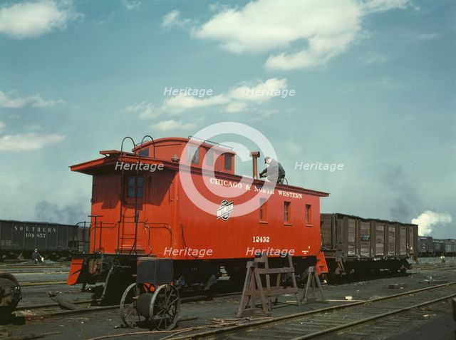 C & NW RR putting the finishing touches on a rebuilt caboose..., Proviso yard, Chicago, Ill., 1943. Creator: Jack Delano.