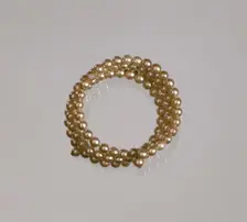 Gold pearl coil bracelet from Mae's Millinery Shop, 1941-1994. Creator: Unknown