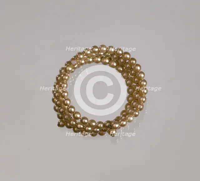 Gold pearl coil bracelet from Mae's Millinery Shop, 1941-1994. Creator: Unknown.