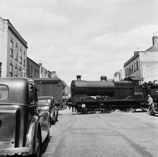 Goods vehicles being shunted across the un-gated level crossing in High Street, Tewkesbury, 1947. Creator: Marjory L Wight
