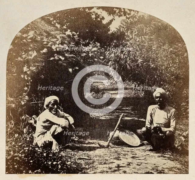 Goruckpoor, India: two men sqatting on a tree-lined path, c1860s. Creator: Unknown.
