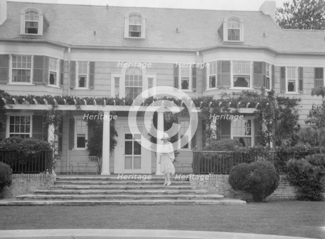 Gossler, Philip, Mrs., standing in front of residence, between 1927 and 1929. Creator: Arnold Genthe.