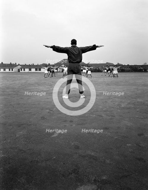 Games master taking a gym class, Airedale school, Castleford, West Yorkshire, 1962. Creator: Michael Walters.