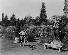 Gardener pushing lawn mower, posed to illustrate Rudyard Kipling's poem The Glory of the Garden,1917 Creator: Frances Benjamin Johnston