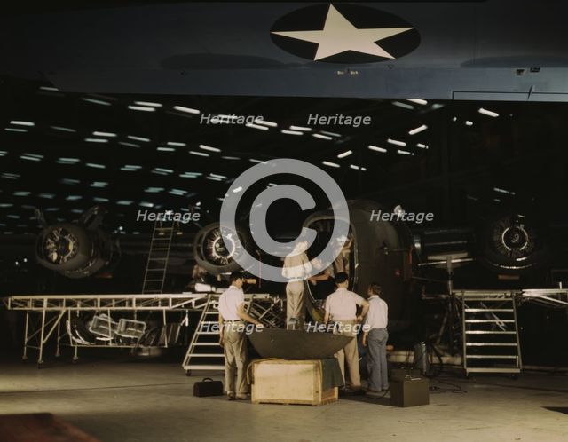 Getting a nose door ready to put on a C-87...Consolidated Aircraft Corp..., Fort Worth, Texas, 1942. Creator: Howard Hollem.