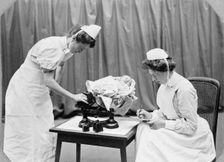 General Lying In Hospital, York Road, Lambeth: nurses weighing a baby, 1908. Creator: Unknown