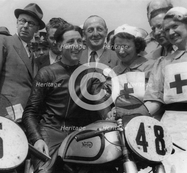 Geoff Duke on Norton, with nurses after race in 1951. Creator: Unknown.