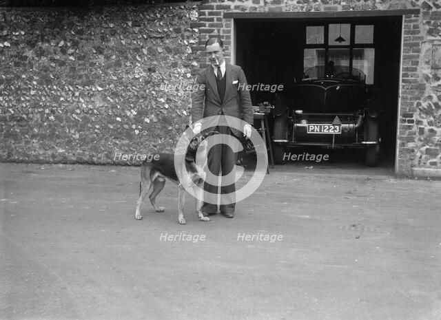 Geoffrey Baker standing in front of a Minerva 5954 cc car. Artist: Bill Brunell.
