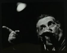 George Melly on stage at the Forum Theatre, Hatfield, Hertfordshire, 8 April 1983. Creator: Denis Williams
