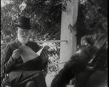 George Bernard Shaw and a Male Civilian Sitting in a Garden, 1920s. Creator: British Pathe Ltd
