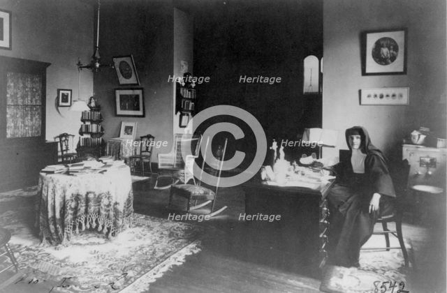 Georgetown Convent, Washington, D.C. - nun seated at desk in furnished room, not after 1892. Creator: Frances Benjamin Johnston.