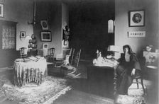 Georgetown Convent, Washington, D.C. - nun seated at desk in furnished room, not after 1892. Creator: Frances Benjamin Johnston