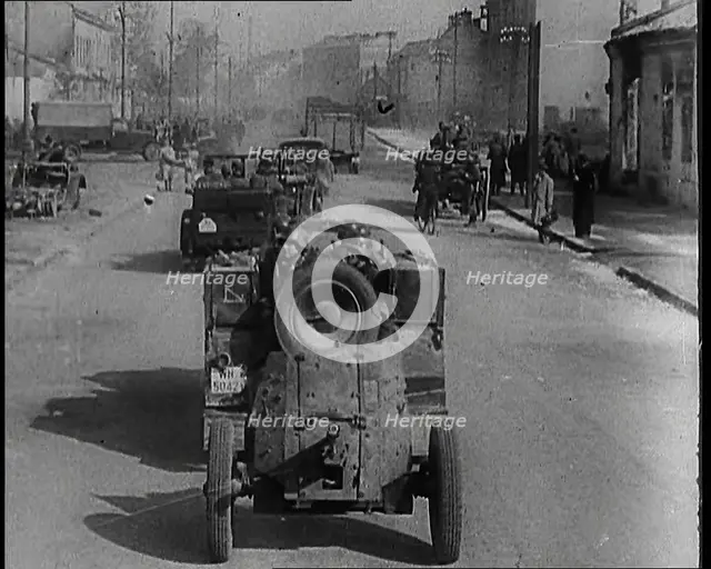 German Army Vehicles With Male Soldiers in Them Driving Down a Street in Warsaw Past..., 1939. Creator: British Pathe Ltd.