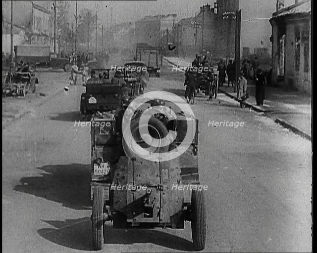German Army Vehicles With Male Soldiers in Them Driving Down a Street in Warsaw Past..., 1939. Creator: British Pathe Ltd.