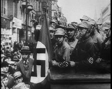 German Civilians and Men in Nazi Uniforms With a Nazi Flag, 1933. Creator: British Pathe Ltd
