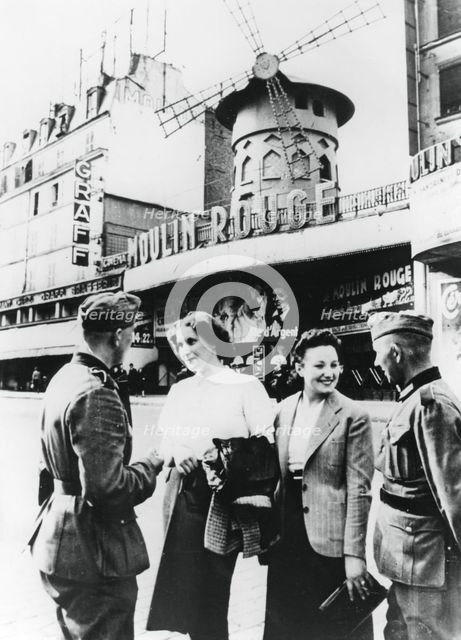 German soldiers chatting up French women outside the Moulin Rouge, occupied Paris, June 1940. Artist: Unknown