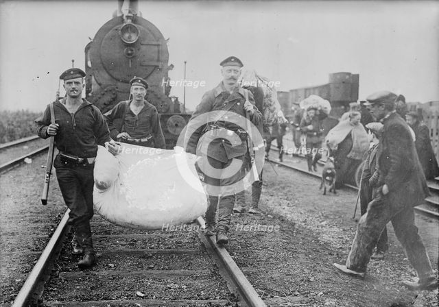 Germans helping refugees returning to Antwerp, 1914. Creator: Bain News Service.