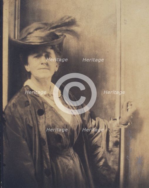 Gertrude Ka¨sebier, wearing feathered hat, standing, facing front, half-length portrait, c1900. Creator: Adolph de Meyer.