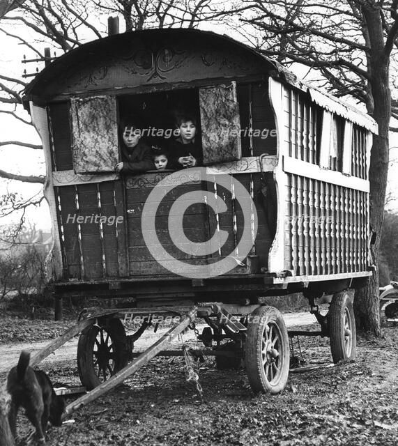 Gipsy children looking out of their caravan by the roadside, Charlwood, Surrey, 1964.