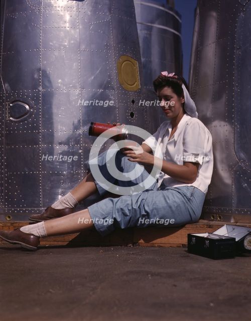 Girl worker at lunch also absorbing Calif..., Douglas Aircraft Company, Long Beach, Calif., 1942. Creator: Alfred T Palmer.