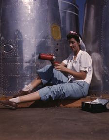 Girl worker at lunch also absorbing Calif..., Douglas Aircraft Company, Long Beach, Calif., 1942. Creator: Alfred T Palmer