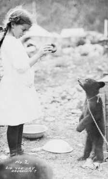 Girl and bear cub, between c1900 and 1916. Creator: Unknown