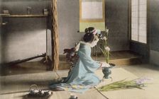 Girl arranging flowers, 1890's. Creator: Japanese Photographer (19th Century)