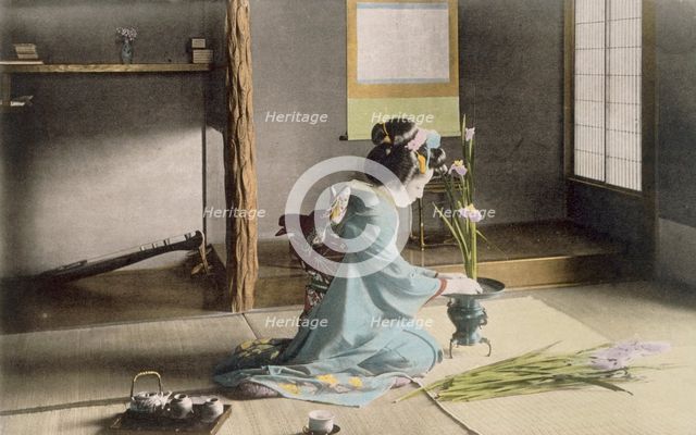 Girl arranging flowers, 1890's. Creator: Japanese Photographer (19th Century).