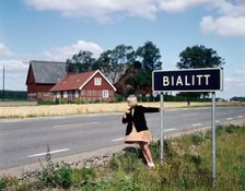 Girl by a road sign for Bialitt, Sweden. Creator: Torkel Lindeberg