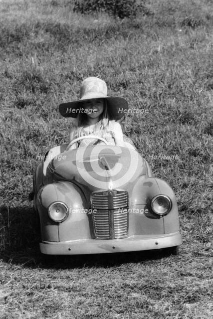 Girl in a 1948 vintage Austin J40 pedal car. Artist: Unknown