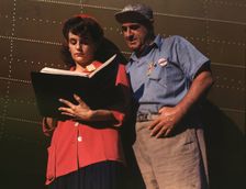 Girl inspector confers with a worker as she..., Douglas Aircraft Company, Long Beach, Calif., 1942. Creator: Alfred T Palmer