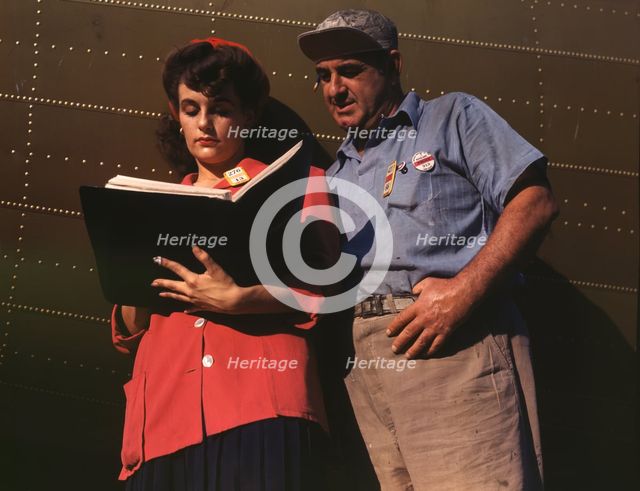 Girl inspector confers with a worker as she..., Douglas Aircraft Company, Long Beach, Calif., 1942. Creator: Alfred T Palmer.