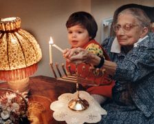 Girl lighting candles, Middlesex, London, 1989. Creator: Unknown