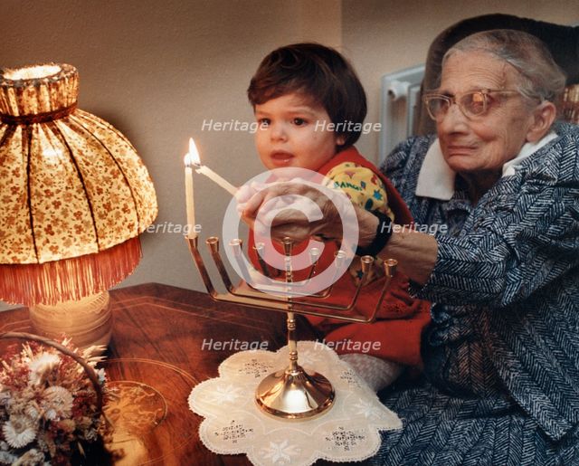 Girl lighting candles, Middlesex, London, 1989. Creator: Unknown.