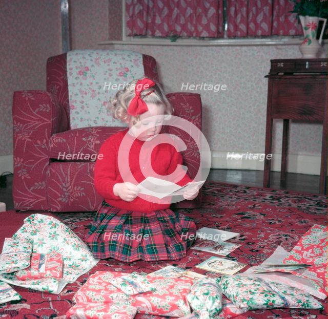 Girl opening her Christmas cards and presents, c1955.  Creator: Arthur Charles Kirby Ware.