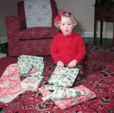 Girl opening her Christmas presents, c1955. Creator: Arthur Charles Kirby Ware