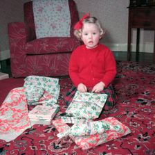 Girl opening her Christmas presents, c1955. Creator: Arthur Charles Kirby Ware