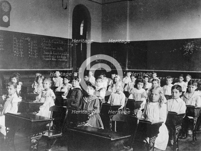 Girls and boys seated at desks in classroom, Washington, D.C., (1899?). Creator: Frances Benjamin Johnston.