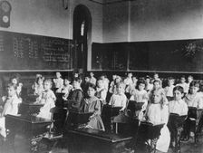 Girls and boys seated at desks in classroom, Washington, D.C., (1899?). Creator: Frances Benjamin Johnston