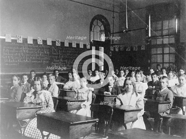 Girls and boys seated at desks in Washington, D.C. classroom, (1899?). Creator: Frances Benjamin Johnston.