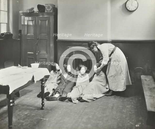Girls drying their hair by the fire after a bath, Chaucer Cleansing Station, London, 1911. Artist: Unknown.