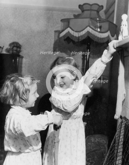 Girls hanging up Christmas stockings, c1955. Creator: Arthur Charles Kirby Ware.