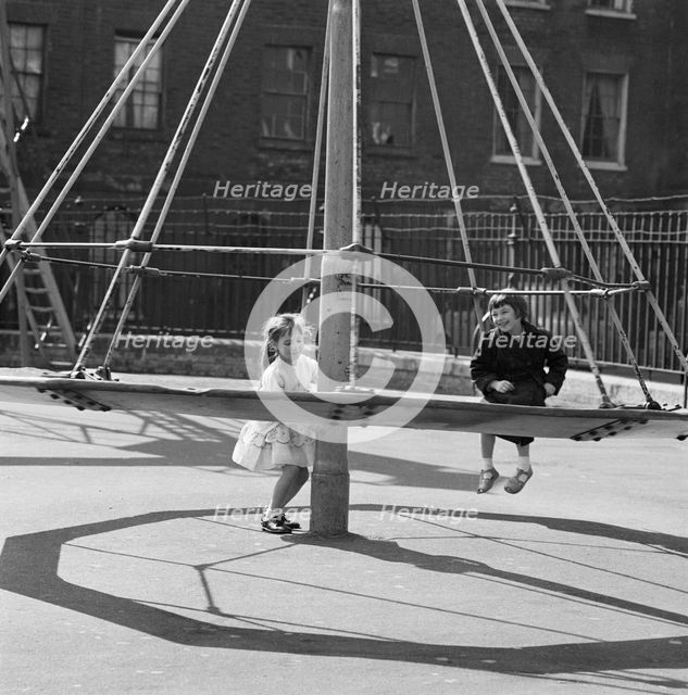Girls playing on a 'witch's hat' in a playground, London, 1960-1965. Artist: John Gay