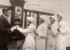Girls queue at the Clocking-In machine, Rowntree factory, York, Yorkshire, 1933