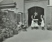 Girls relaxing in a roof top garden, White Lion Street School, London, 1912